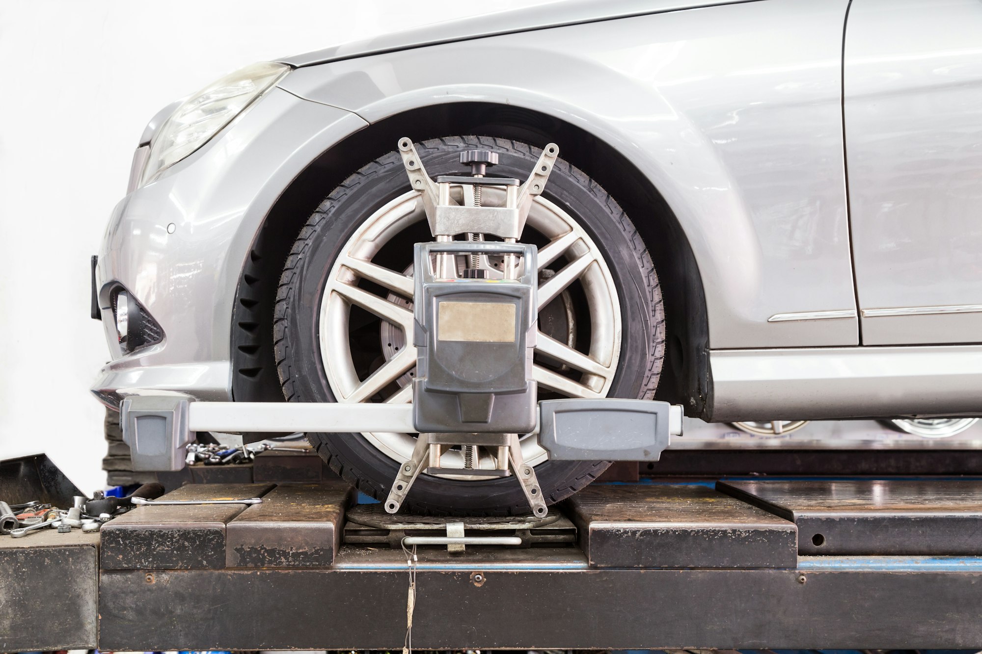Closeup of tire clamped with aligner undergoing auto wheel align