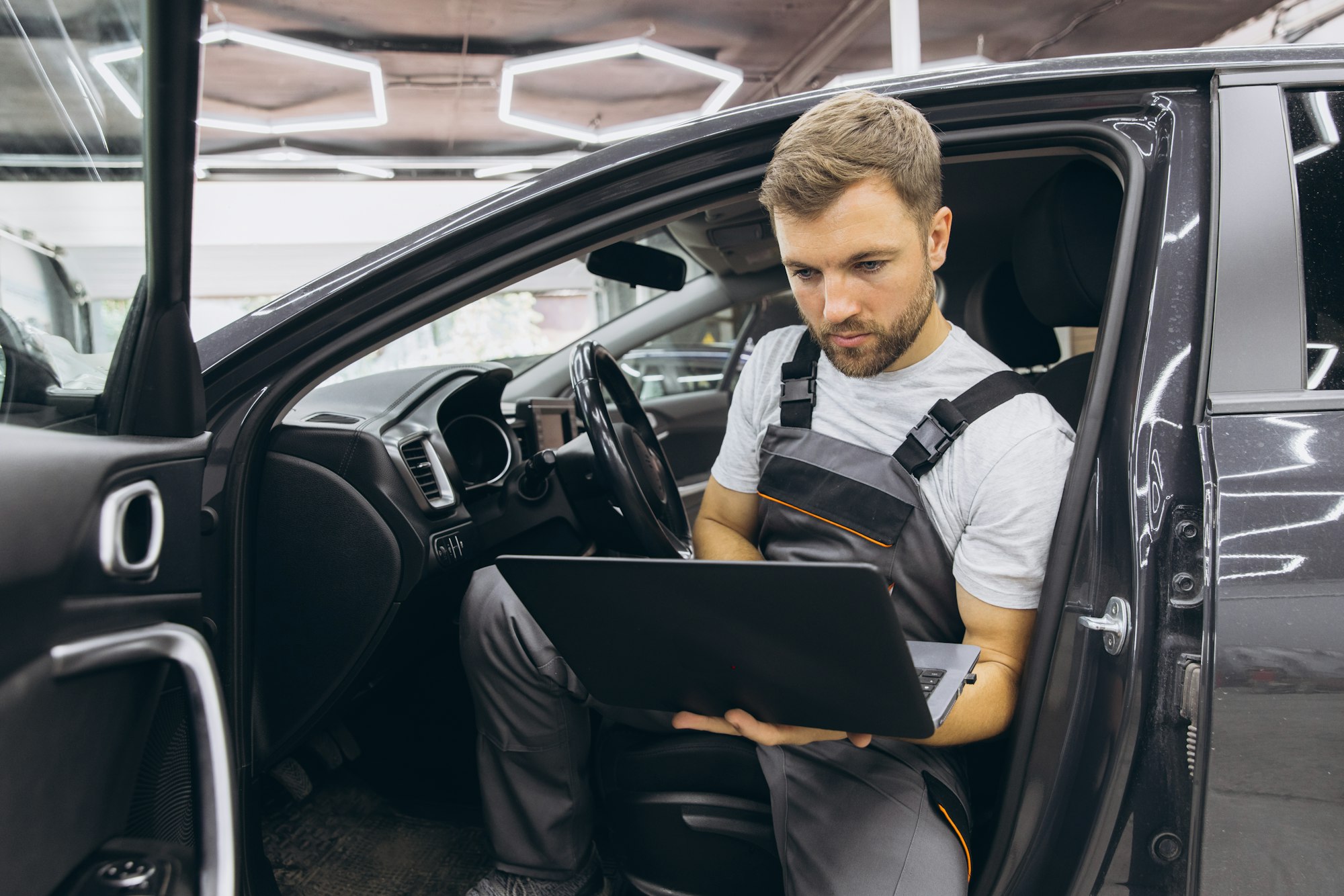 Automotive mechanic running diagnostics software on computer.