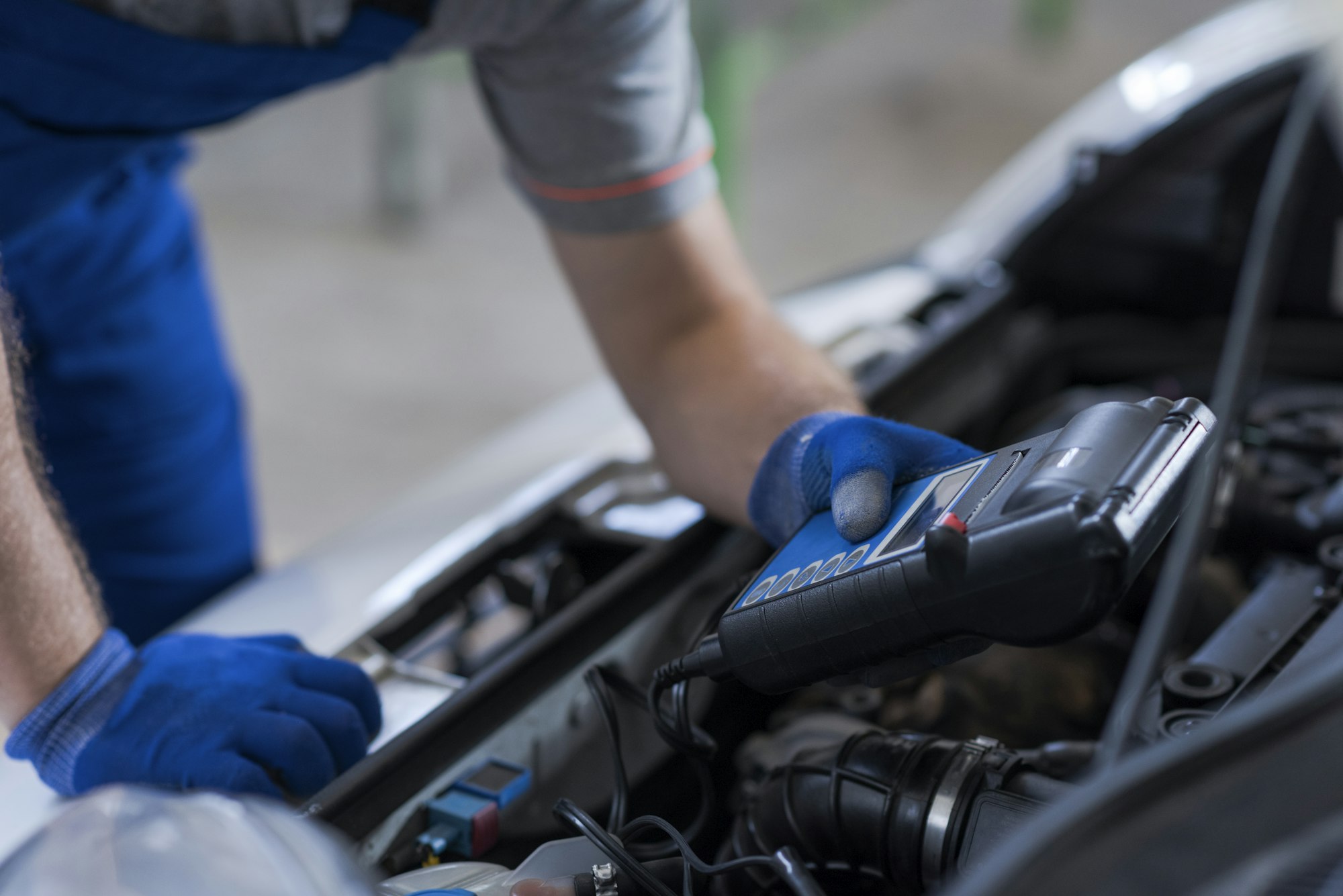 Mechanic using a battery tester